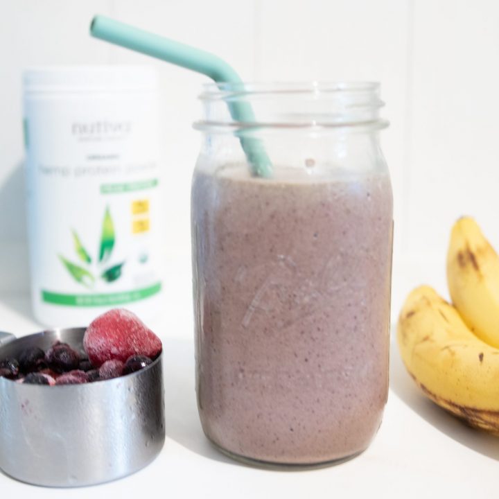 smoothie with berries and bananas surrounding
