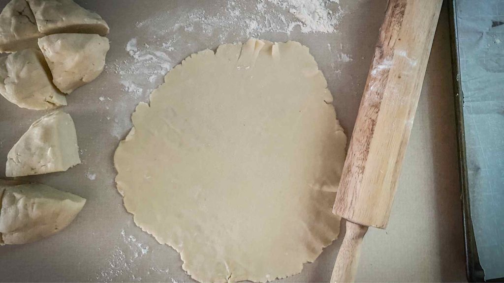 sourdough crust rolled out with rolling pin next to it