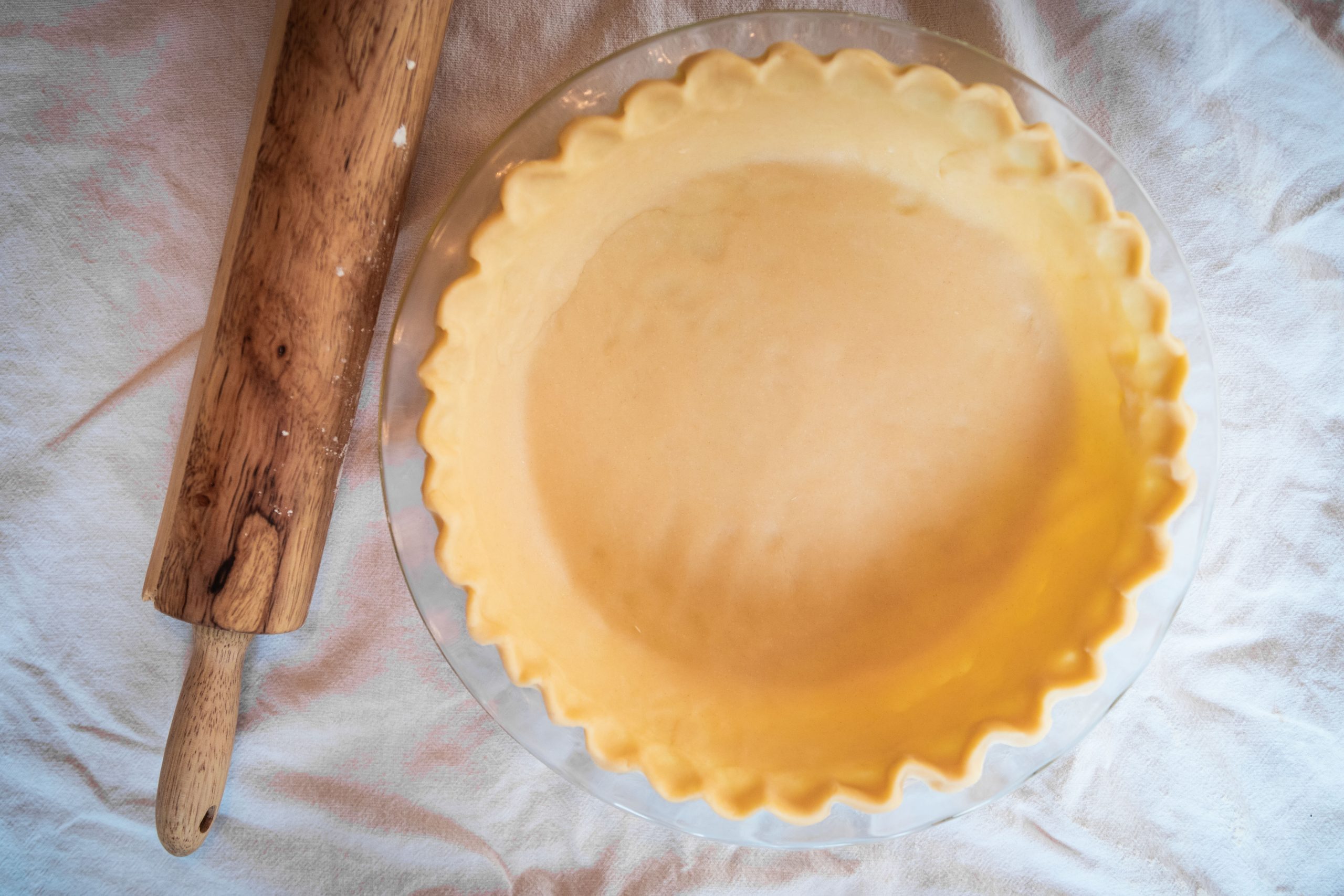 sourdough pie crust in dish with rolling pin