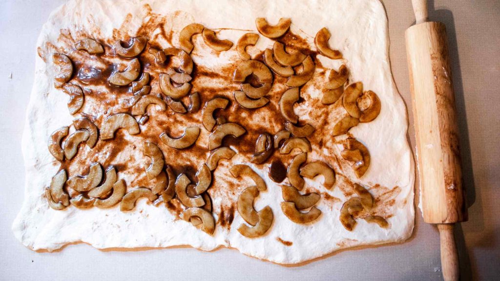 apple pie filling spread out on dough