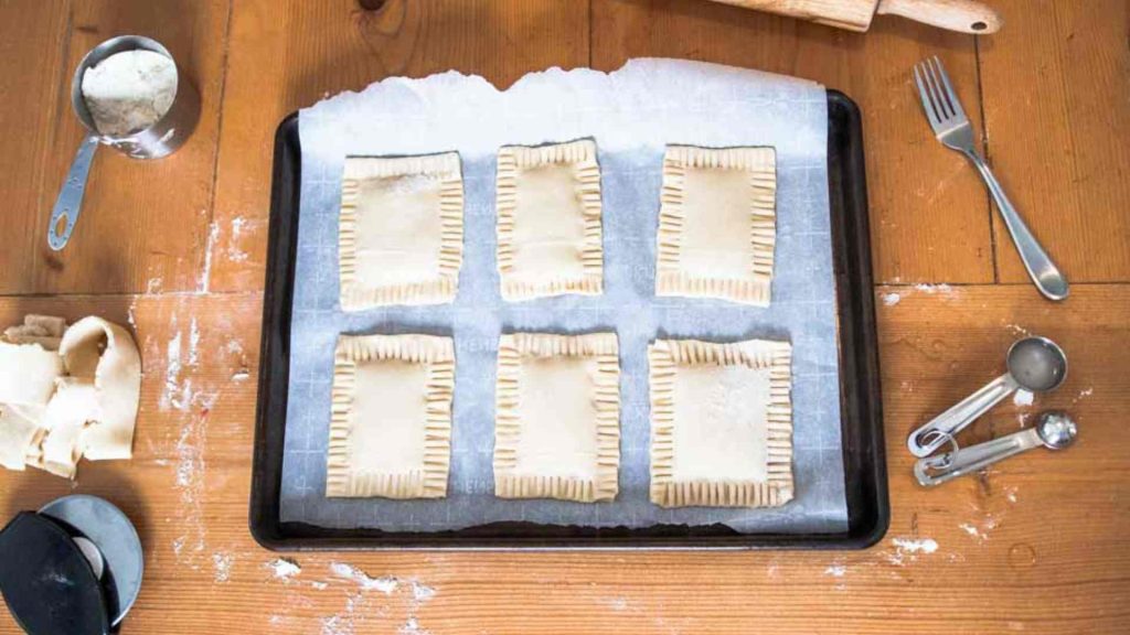 uinbaked sourdough pop tarts on a baking sheet with supplies surrounding