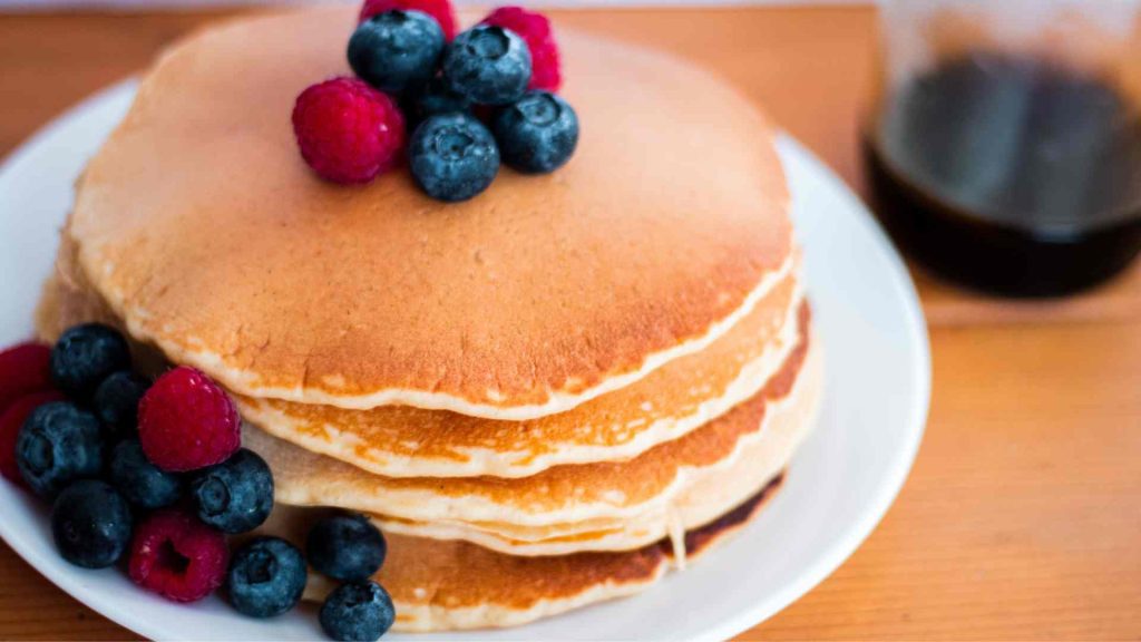 stack of classic sourdough pancakes with butter and fresh berries