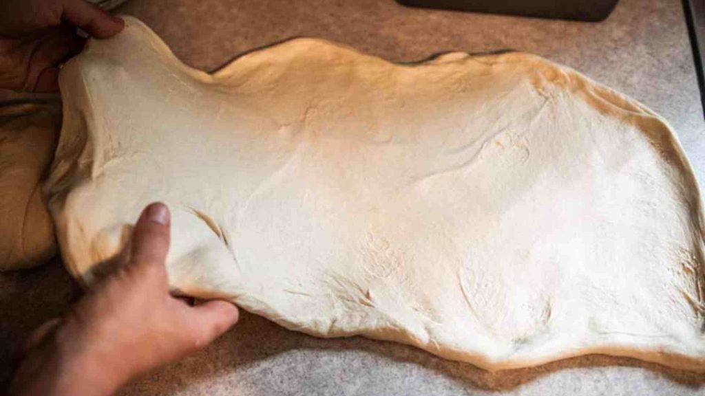 soft sourdough bread dough spread out into a rectangle