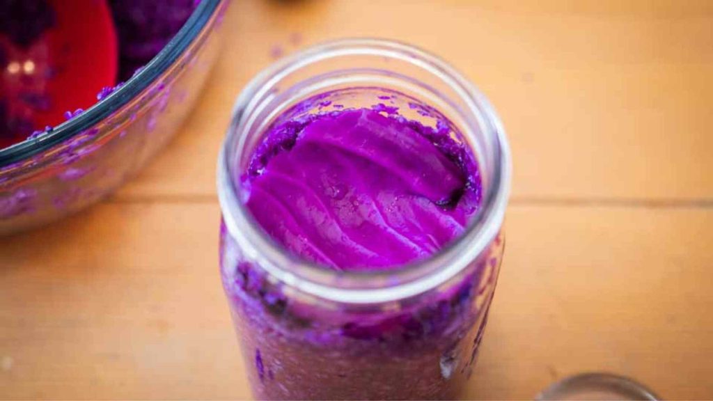 red cabbage leaf on top of the shredded cabbage in a mason jar