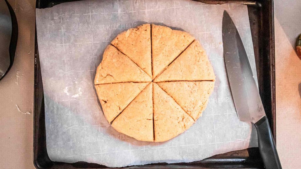 pumpkin sourdough scone dough shaped into a circle and cut