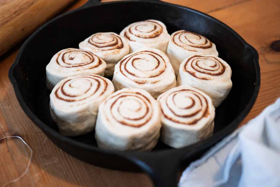 a cast iron skillet with unbaked cinnamon rolls in it