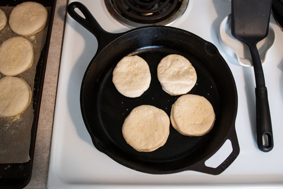 sourdough english muffins frying in a cast iron