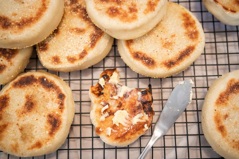 a toasted english muffin spread with butter with a bite out of it