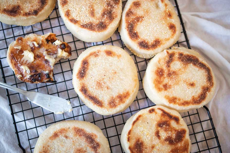 sourdough english muffins, one is toasted with butter on it