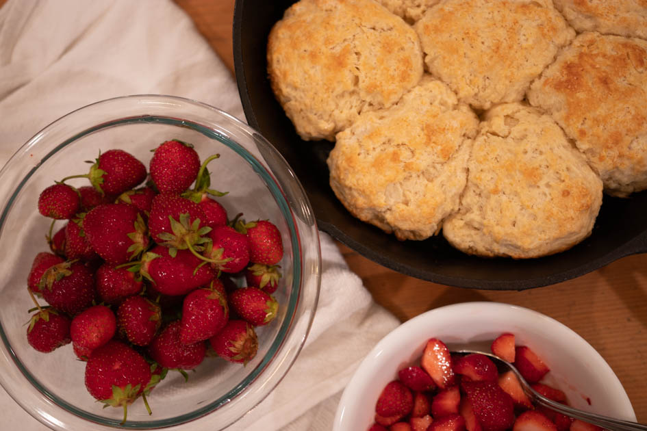 fresh strawberries in a bowl with sourdough biscuits and strawberry sauce
