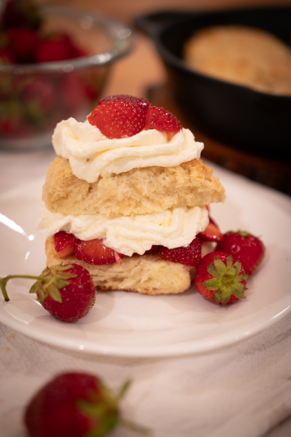 sourdough strawberry shortcake on a white plate with whole strawberries