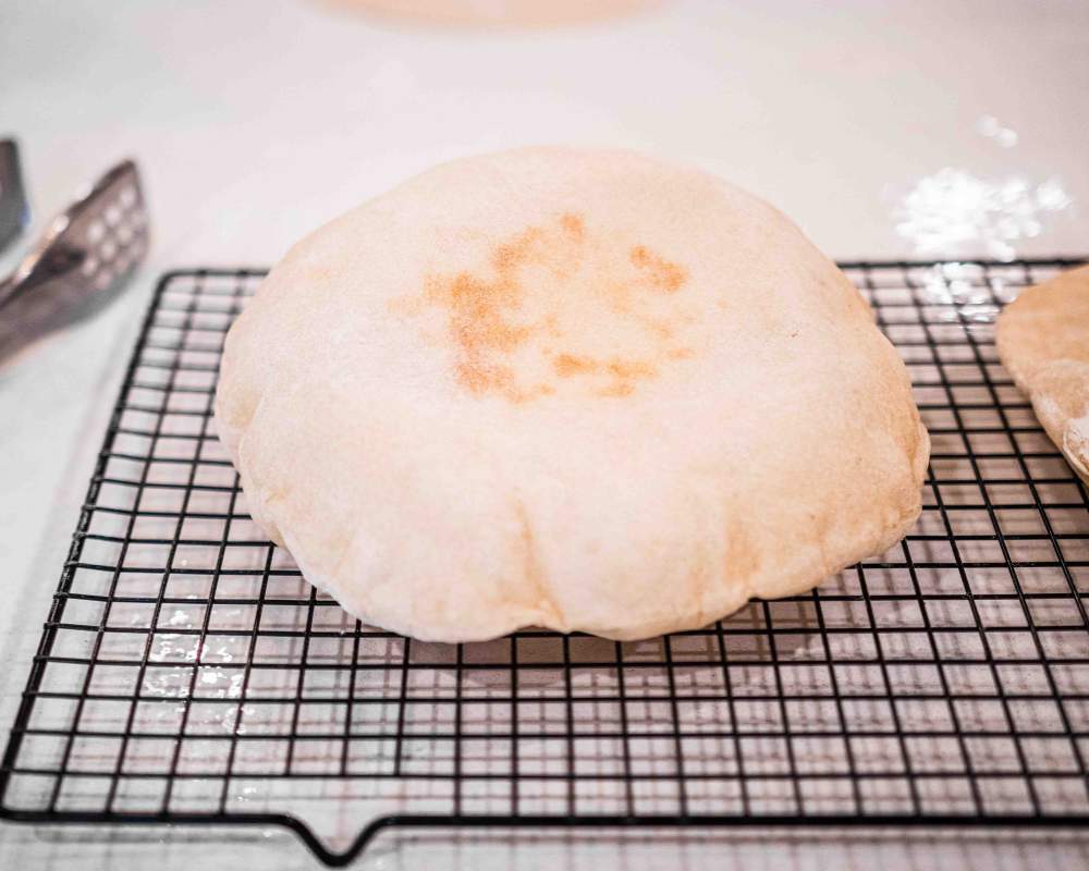 top view of sourdough pita bread on a cooling rack